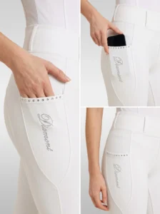 Close-up details of white competition breeches: crystal-trimmed side phone pocket and Diamont script