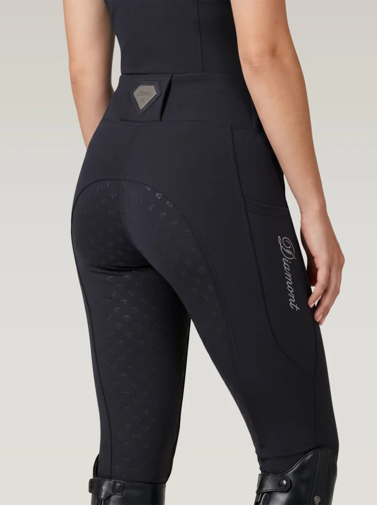 Back three-quarter view of black equestrian leggings with full-seat diamond grip, waistband badge and Diamont rhinestone script