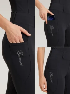 Close-up details of black riding leggings: side phone pocket holding a smartphone and Diamont rhinestone script