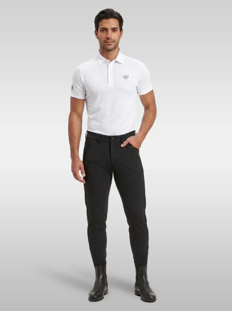 Rider wearing the white Cavalier men’s equestrian polo shirt with black riding breeches and black riding boots, full body