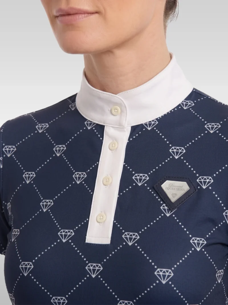 Close-up of the navy Diamont base layer: white stand-up collar, button placket, diamond monogram print and silver metal diamond badge