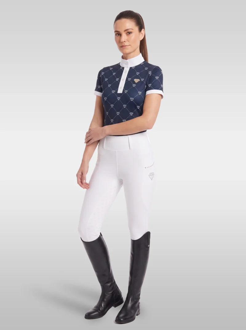 Rider wearing the navy Diamont base layer with white riding breeches and tall black riding boots, full body