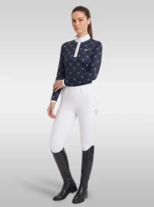 Rider wearing the navy Diamont long sleeve base layer with white riding breeches and tall black riding boots, full body