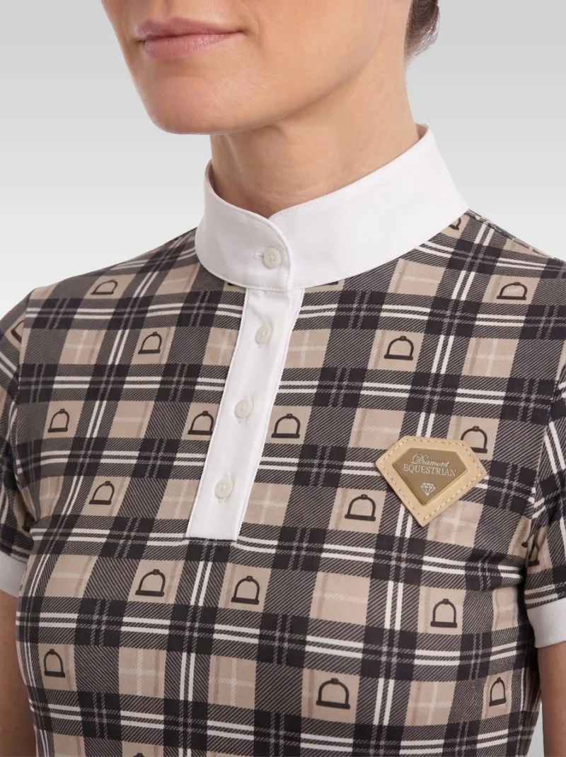 Close-up of the beige Heritage base layer: white stand-up collar, button placket, check print with stirrup motif and gold metal diamond badge