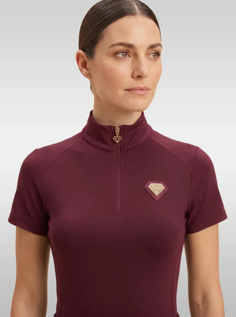 Front view of the burgundy Prestige base layer by Diamont Equestrian with high collar, gold zip and diamond badge