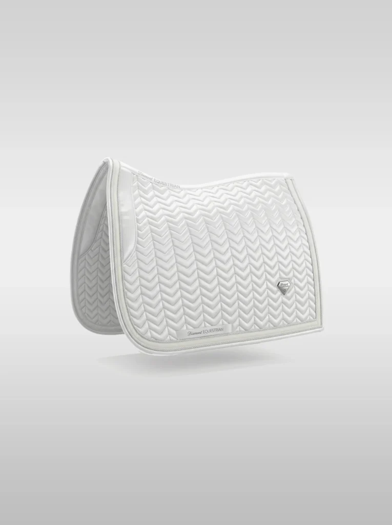 White Prestige dressage saddle pad by Diamont Equestrian with chevron quilting, contrast piping and a metal diamond badge