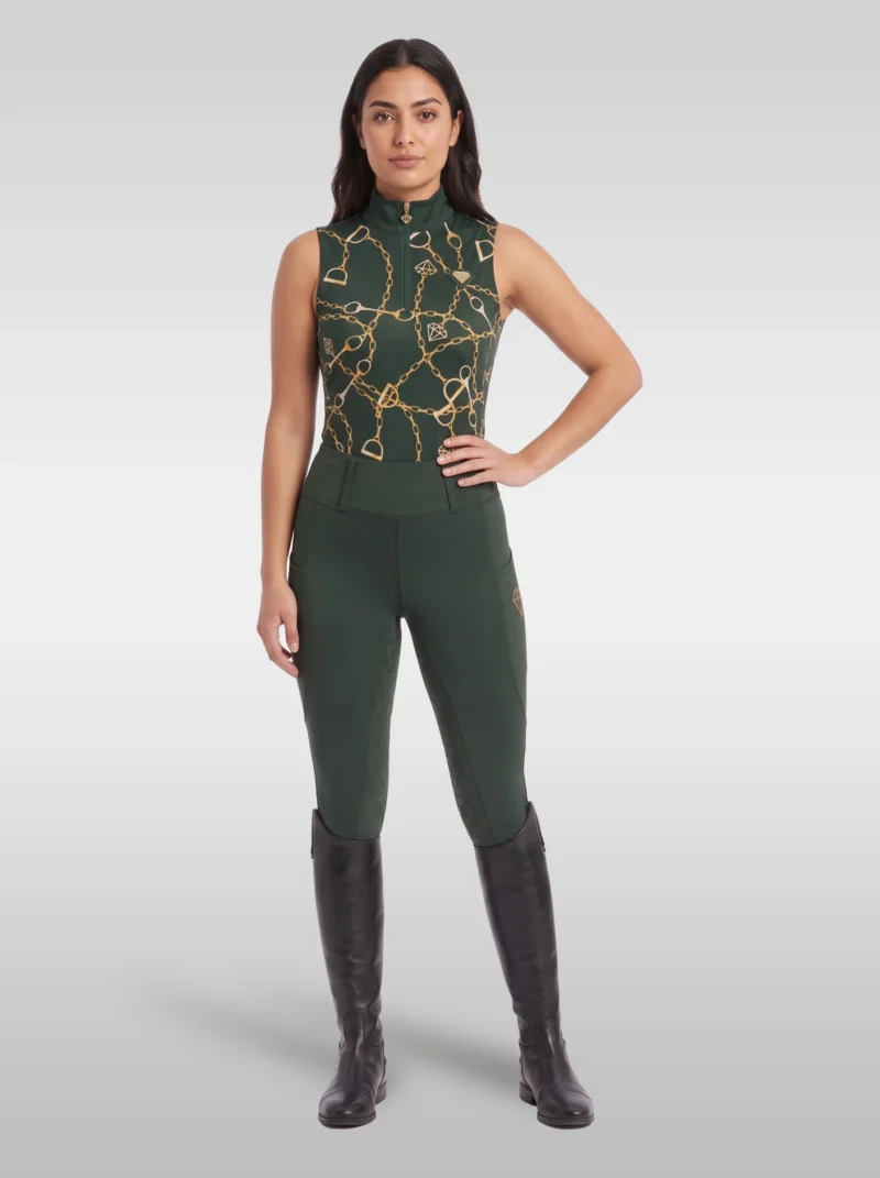 Rider wearing the green Signature sleeveless base layer with matching green riding leggings and tall black riding boots, full body