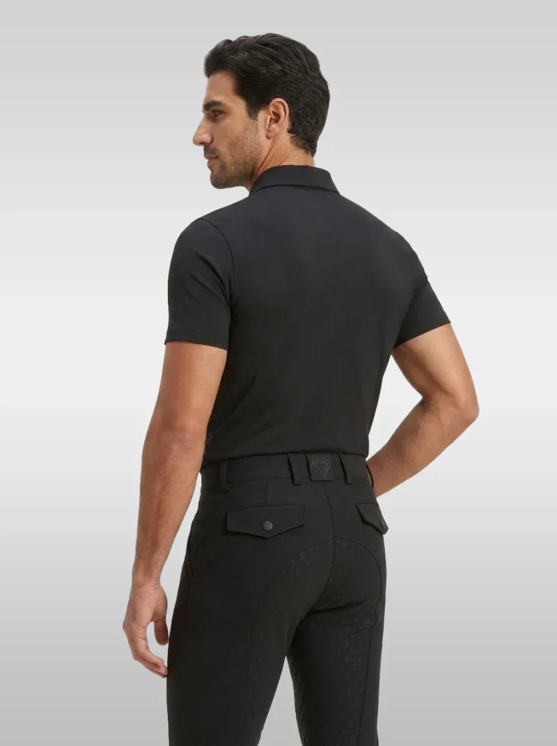 Back three-quarter view of the black Cavalier men’s polo shirt worn with black riding breeches