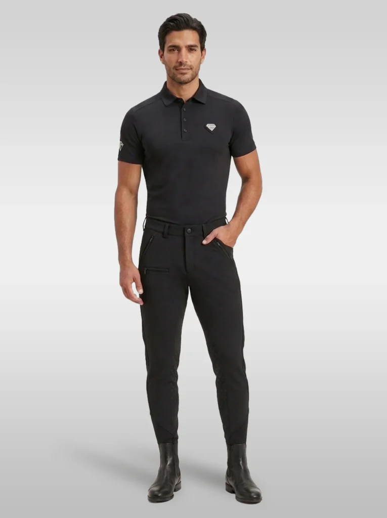 Rider wearing the black Cavalier men’s equestrian polo shirt with black riding breeches and black riding boots, full body