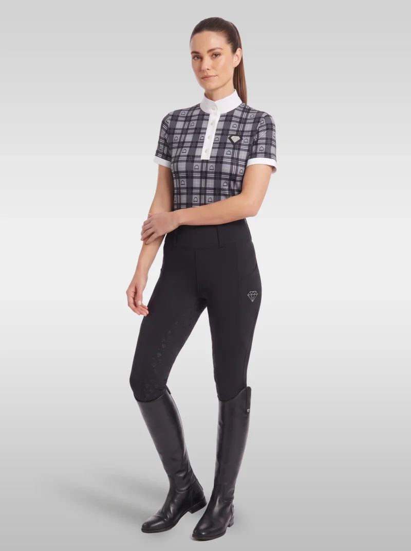 Rider wearing the grey Heritage check base layer with black riding leggings and tall black riding boots, full body