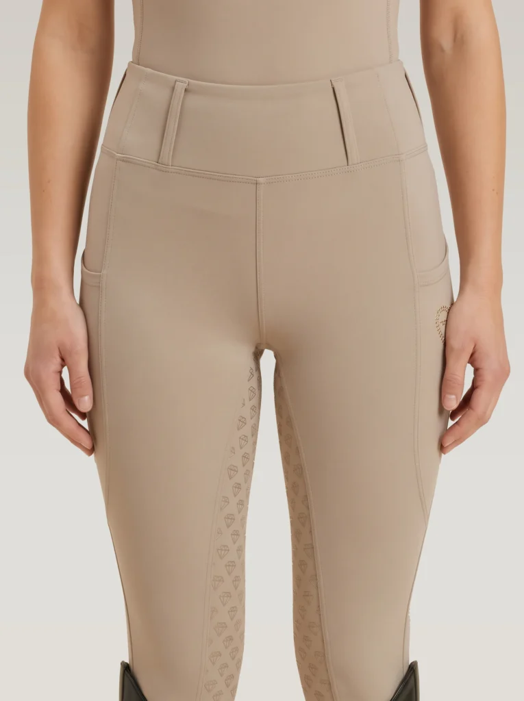 Front view of beige Prestige riding leggings by Diamont Equestrian with high-rise waistband and belt loops