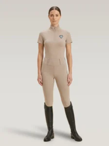 Rider wearing beige Prestige riding leggings with a matching Diamont Equestrian base layer and tall riding boots, full body