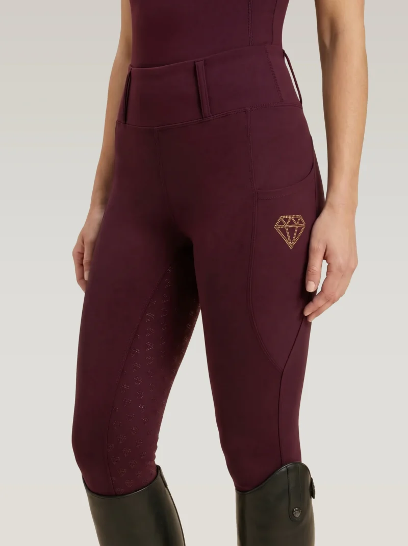 Burgundy Prestige riding leggings by Diamont Equestrian with diamond logo on the side pocket and diamond silicone grip, front three-quarter view