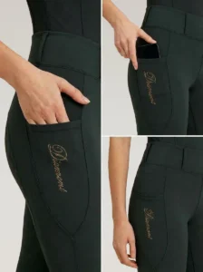Close-up details of green riding leggings: side phone pocket holding a smartphone and Diamont script