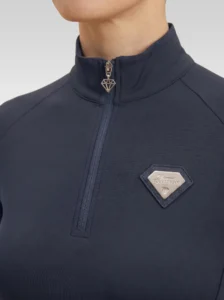 Close-up of the navy Prestige base layer: silver zip with diamond pull and silver metal Diamont Equestrian badge in a navy leather frame