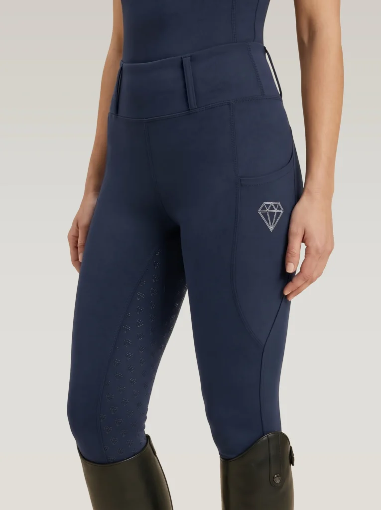 Navy Prestige riding leggings by Diamont Equestrian with diamond logo on the side pocket and diamond silicone grip, front three-quarter view