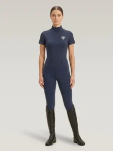 Rider wearing navy Prestige riding leggings with a matching Diamont Equestrian base layer and tall riding boots, full body