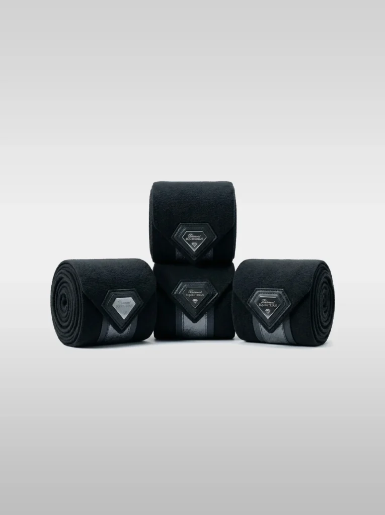 Set of four black Prestige fleece polo wraps by Diamont Equestrian with a metal diamond badge in a leather frame