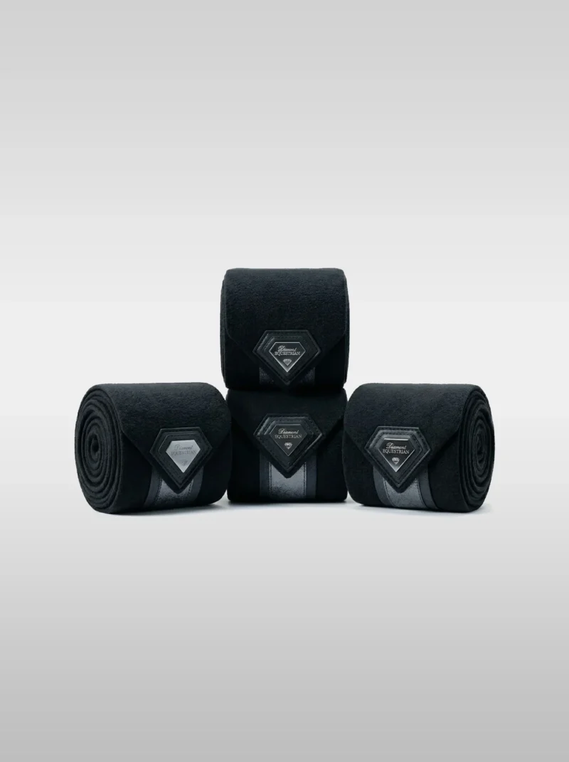 Set of four black Prestige fleece polo wraps by Diamont Equestrian with a metal diamond badge in a leather frame