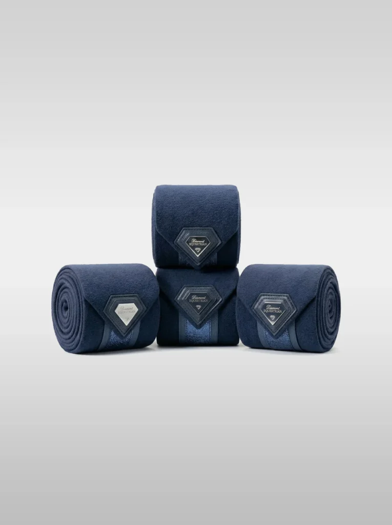Set of four navy Prestige fleece polo wraps by Diamont Equestrian with a metal diamond badge in a leather frame
