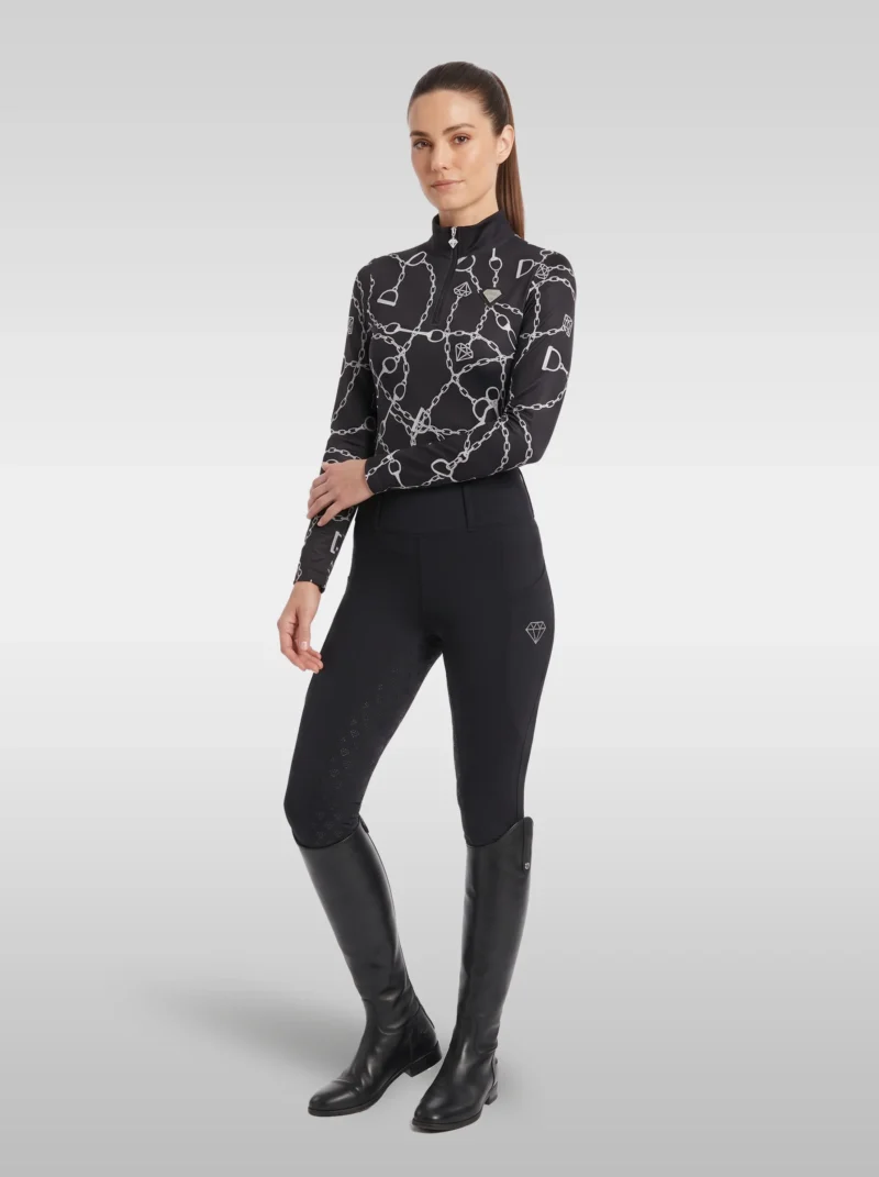 Rider wearing the black Signature long sleeve base layer with black riding leggings and tall black riding boots, full body