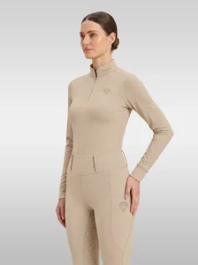 Beige Prestige long sleeve base layer by Diamont Equestrian with quarter-zip, perforated sleeves and gold metal diamond badge, front three-quarter view