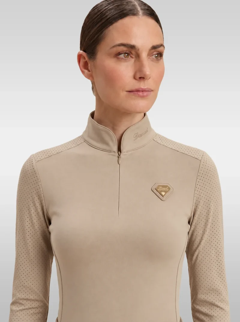 Front view of the beige Prestige long sleeve base layer by Diamont Equestrian with high collar, zip and gold diamond badge