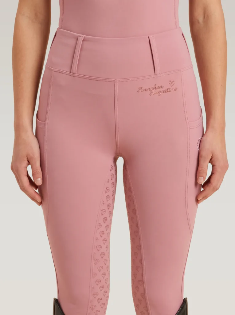Front view of blush pink Allure riding leggings by Diamont Equestrian with high-rise waistband and belt loops