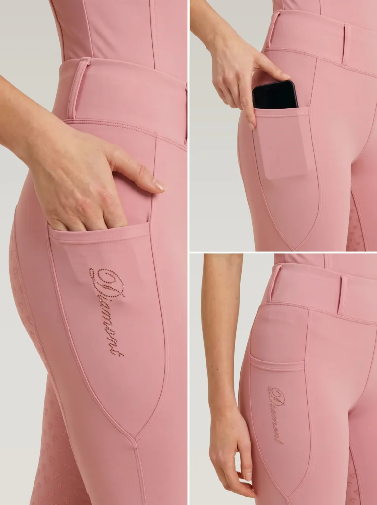 Close-up details of blush pink riding leggings: side phone pocket holding a smartphone and Diamont script