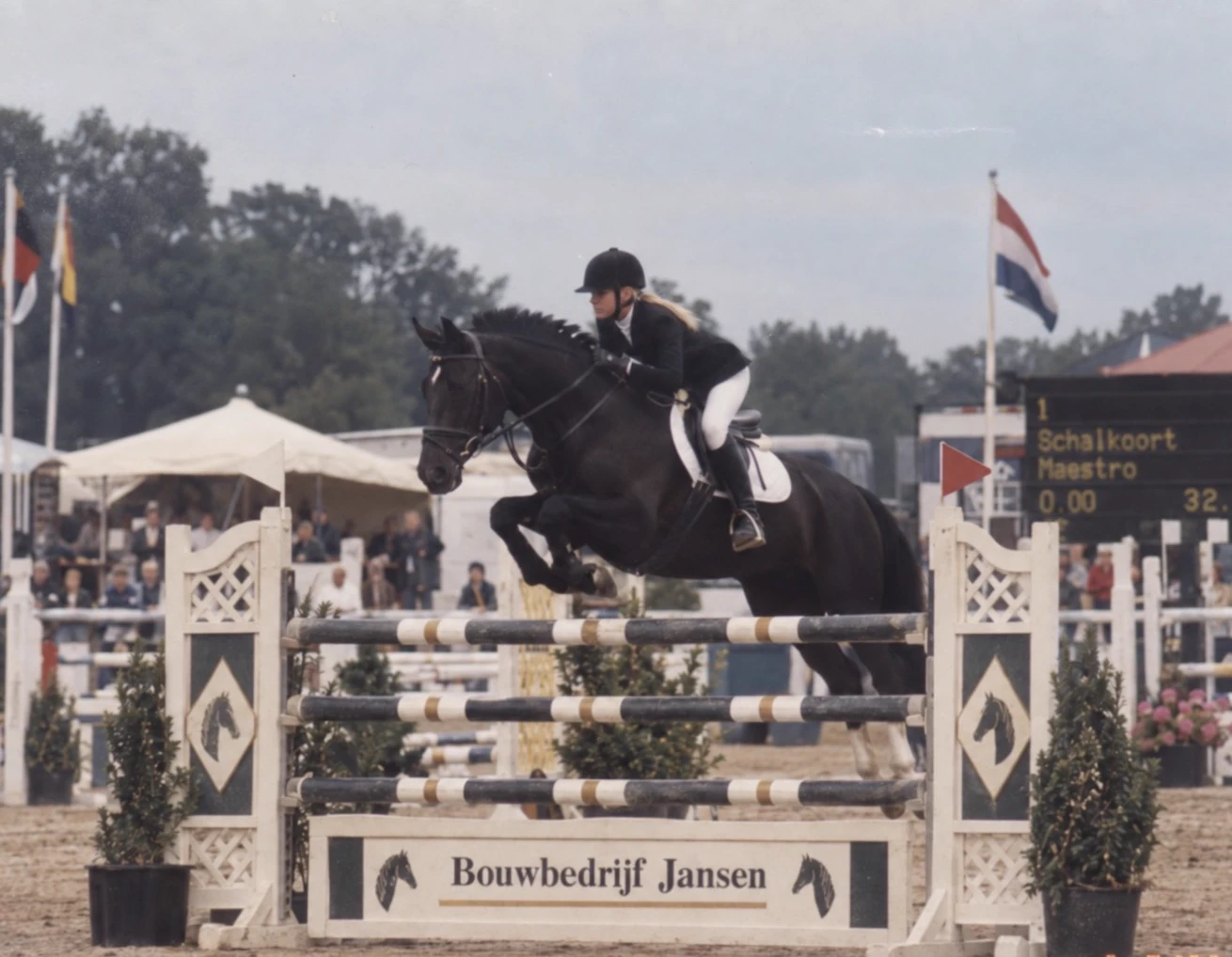 Nanda show jumping a black horse at a competition in the Netherlands in 2002