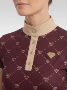 Close-up of the burgundy Diamont base layer: beige stand-up collar, button placket, gold diamond monogram print and gold metal diamond badge