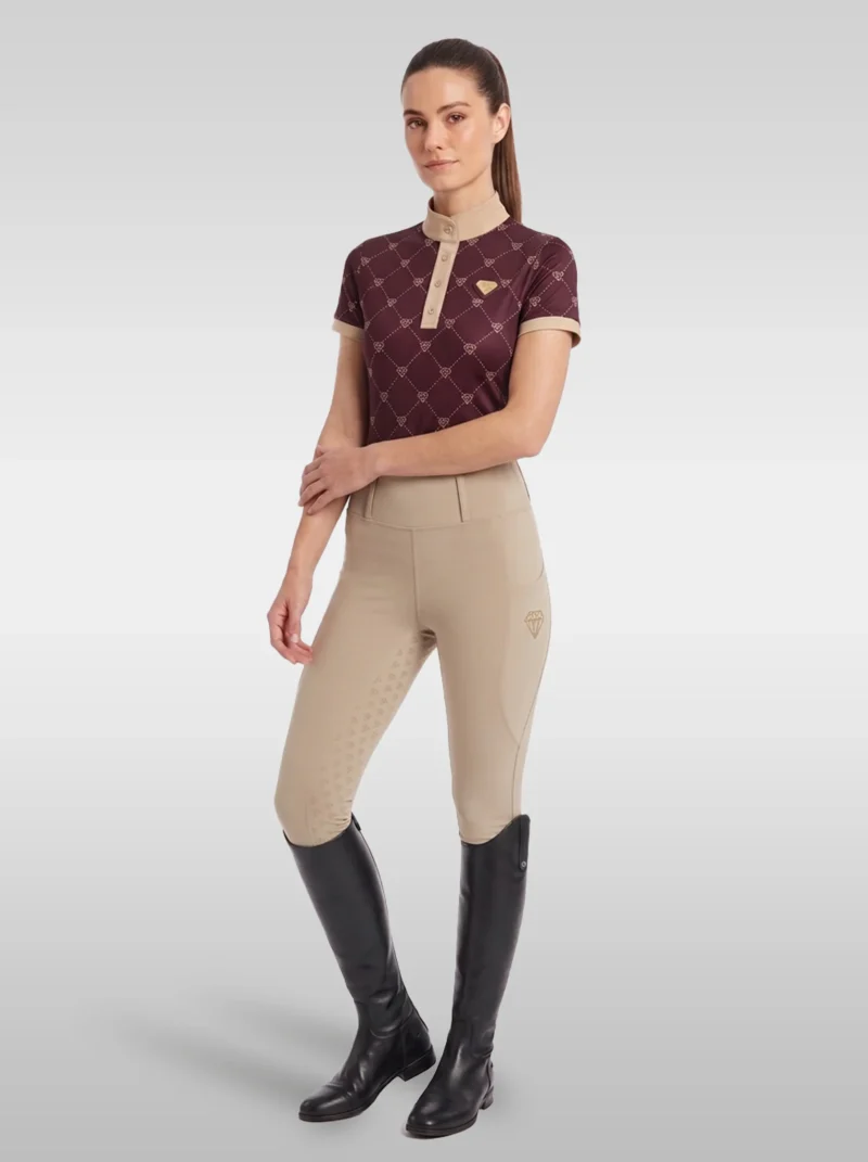 Rider wearing the burgundy Diamont base layer with beige riding breeches and tall black riding boots, full body