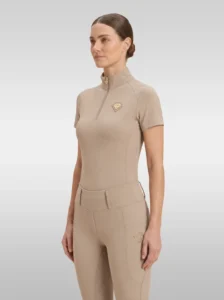 Beige Prestige base layer by Diamont Equestrian with gold quarter-zip and gold metal diamond badge on the chest, front three-quarter view