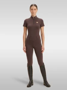 Rider wearing the chocolate brown Prestige base layer with matching chocolate riding leggings and tall riding boots, full body