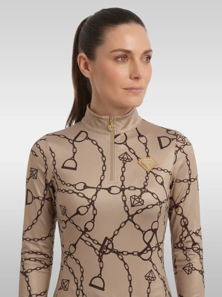 Front view of the beige Signature long sleeve equestrian base layer with stand-up collar, gold zip and gold diamond badge